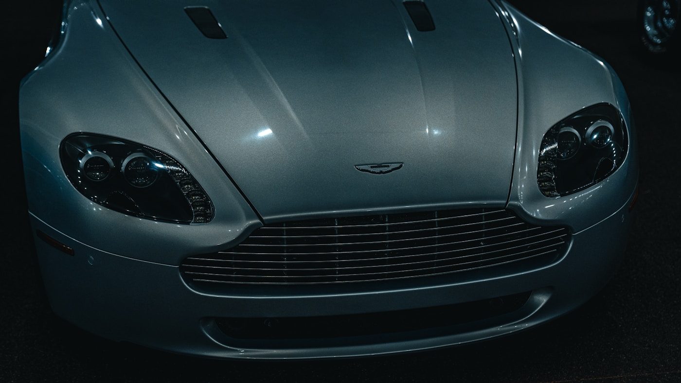 Full front end of a glossy sports car showing the bumper, hood, fenders, and headlights